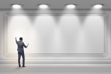 Businessman pressing virtual button on the wall lit with spotlig
