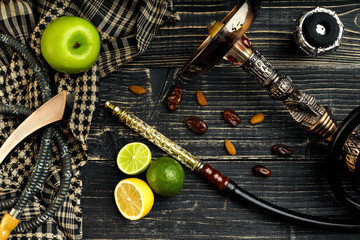 Dismantled parts of hookah on a wooden background with lime and 