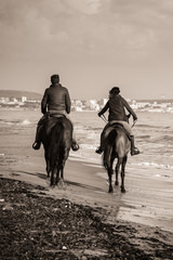 two riders on a wild beach