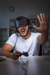 Young man playing games long hours late in the office