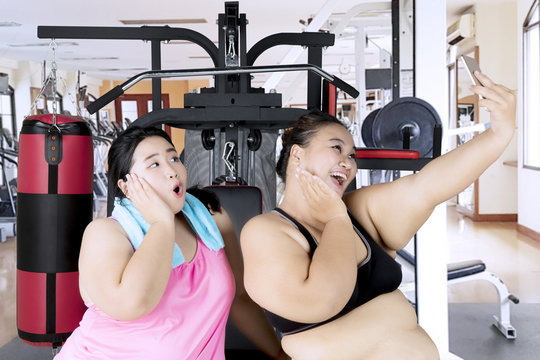 Fat women taking picture in the gym center