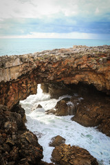 Fototapeta na wymiar Big rock formation with a cave in the center with ocean water inside. Local known as 