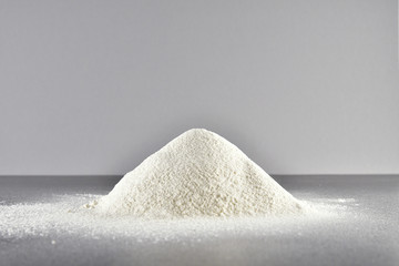 a bunch of sifted flour on a grey background on black table