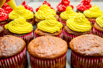 Application of yellow oil cream on muffins.
