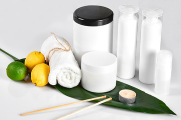 White bottles and two whole lemon and lime isolated on white background. The concept for advertising cosmetics