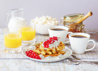 Romantic breakfast with Belgian waffles, honey, red currant, coffee, marshmallow and fresh orange juice