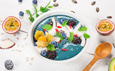 Smoothie bowl with fresh berries, nuts, seeds, fruit and vegetables.