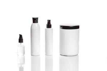 Set of cosmetic products in white containers on light background.