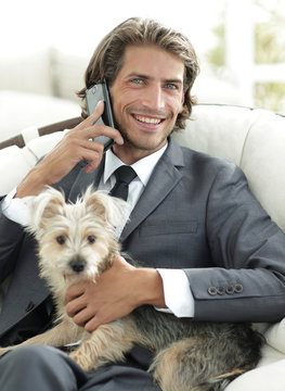 business man talking on the phone and holding his pet