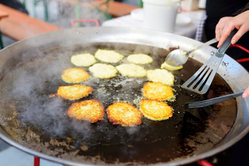 Delicious potato pancakes being fried at one of the stalls on the traditional spring market in Vilnius