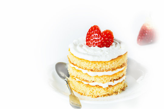 Valentine mini cake with strawberry in heart shape on white plate.