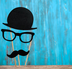 Photo booth props with hat, glasses, mustache on wooden background