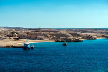 Quiet harbor with ships and sandy shores of the Red Sea.The desert connects to sea.