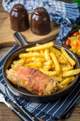 Fried chicken breast stuffed with mushrooms and cheese wrapped in ham served with fries and salad.