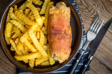 Fried chicken breast stuffed with mushrooms and cheese wrapped in ham served with fries and salad.