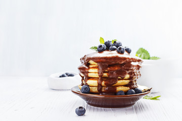 Stack of pancakes with fresh berries served on old black board . Selective focus.