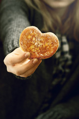 Female hands holding a doughnut shaped of heart, Valentines day and love theme