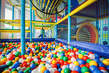 Children playground with colored plastic balls indoor, inside modern gym in kids room, concept of playroom.