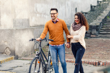 Happy young couple with a bicycle on sunny autumn day in the city