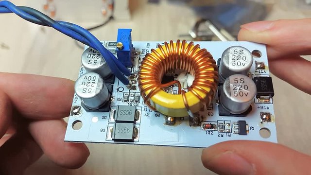 The man adjusts the operation of the LED, connects the power. Repair of electronic devices, tin soldering parts.