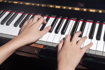 Close up of young girls hands, playing piano.