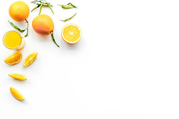 Orange juice in glass near slices of oranges on white background top view copy space