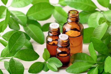 Bitter orange leaf essential oil and fresh leaves on the wooden board