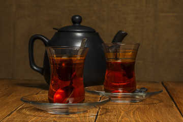 Turkish tea in traditional glass on a wooden table close-up.
