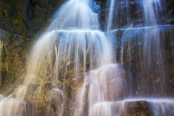 Naklejka na ściany i meble Close-up waterfall in a cave, wild landscape