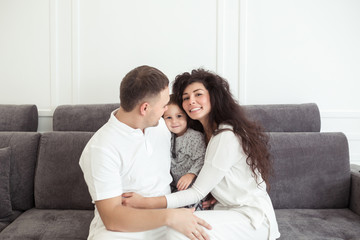 Young happy family, parenthood and people concept. Mother, father and child son at home spending time together