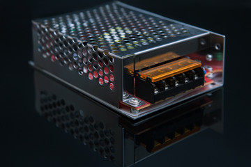 transformer 12W on black background. converts high voltage into low-voltage. engineering technology