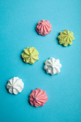 Fototapeta premium Traditional French meringue dessert as a symbol of love and holiday on a blue background.