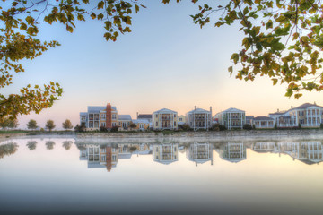 Fototapeta premium suburban neighborhood with lake in foreground with trees
