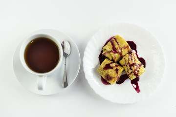 top view of tasty traditional russian pancakes with tea cup on white table