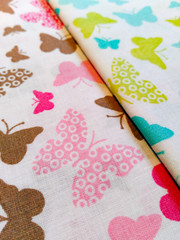 Color fabric patterns, cotton colored samples, variety of species in the background.