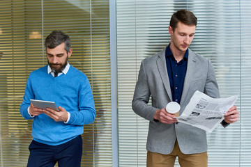 Conceptual waist up portrait  of two business people one young and one mature standing at opposite...