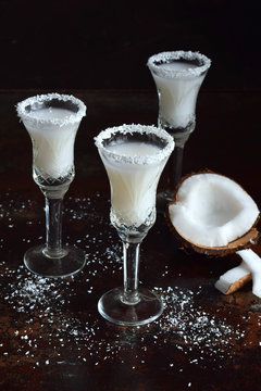 Coconut liqueur in glass with broken coco. Delicious Pinacolada milk cocktail with rum. Alcohol drink liquor. Copy space
