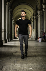 Handsome muscular man with tattoo posing in European city center, Turin, Italy
