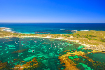 Aerial view of Narrow Neck, Rocky Bay beach and Strickland Bay in Rottnest Island, Australia. Scenic flight over famous tourist destination of Western Australia. Indian Ocean with reef. Copy space.