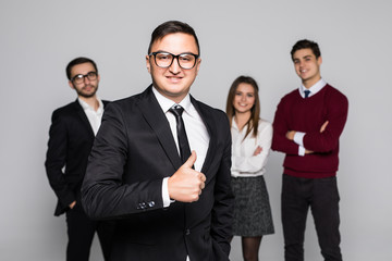 Business man leading a successful corporate group with thumbs up isolated on white