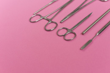 on a pink background is a dental instrument