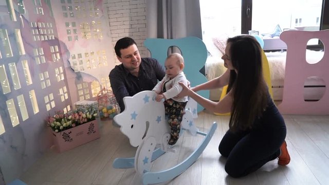 Little girl playing with toy and parents