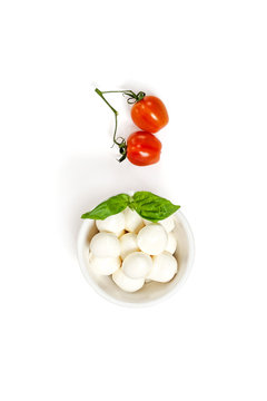 Two fresh Cherry tomatoes and Mozzarella cheese on a clean white background. Isolated.