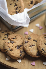 Chocolate chip cookies on a wooden plate and in a little box decotated with sugar hearts. Valentine concept.