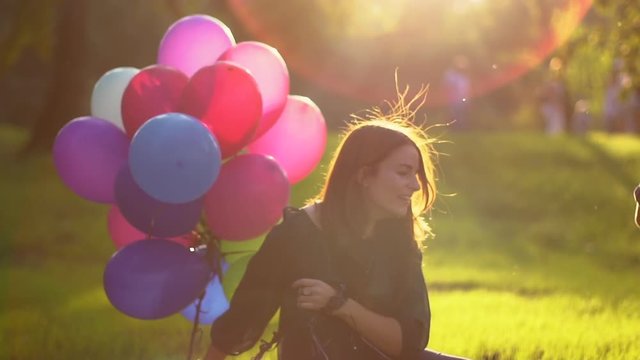 Mom and son playing with balloons in the park