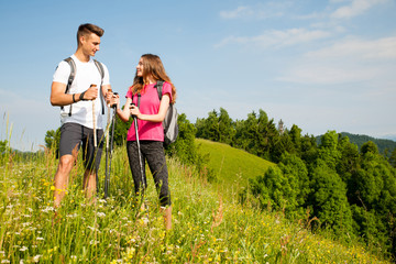 active Beautiful young couple hiking ina nature climbing hill or mountain - man and woman trekking