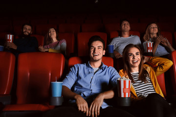 Young people watching movie in cinema - obrazy, fototapety, plakaty
