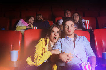 Naklejka premium Young people watching movie in cinema