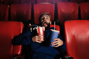 Fototapeta premium Emotional young man watching movie in cinema