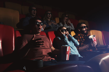 Fototapeta premium Young people watching movie in cinema